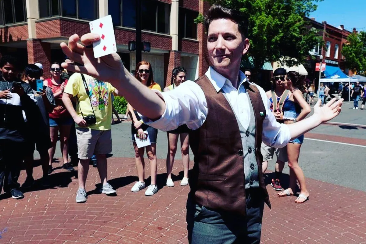 Joe Coover performing card trick at festival