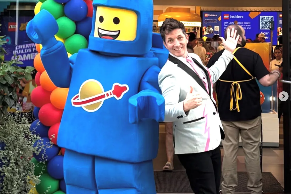Joe Coover at the Lego store with a giant blue Lego figure